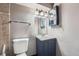 Small, updated bathroom featuring a toilet and vanity with navy blue cabinets at 2904 S Idalia St, Aurora, CO 80013