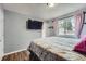 Comfortable bedroom with wood floors, a large window, and television on wall at 2904 S Idalia St, Aurora, CO 80013