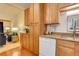 Efficient kitchen layout with wood cabinetry, tile backsplash, and dishwasher at 625 S Alton Way # 10D, Denver, CO 80247