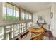 Bright sunroom featuring hardwood floors, brick accent wall, and a round wooden table and chairs at 625 S Alton Way # 10D, Denver, CO 80247