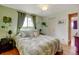 Comfortable bedroom showcasing a queen bed with green accents, hardwood floors, and natural light at 1425 S Newport St, Denver, CO 80224