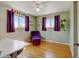 Bright, airy bedroom features hardwood floors, two large windows, and purple accents at 1425 S Newport St, Denver, CO 80224