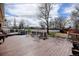 Outdoor deck and backyard featuring a gas grill, comfortable seating, and lush green space at 1425 S Newport St, Denver, CO 80224