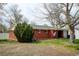 Charming red brick house with a well-manicured lawn and mature trees on a sunny day at 1425 S Newport St, Denver, CO 80224