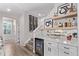 Wet bar located near stairs with wine rack, beverage cooler, and mirrored backsplash at 14998 Cast Pebble Cir, Parker, CO 80134