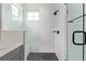 Modern bathroom with white tiling, matte black hardware, glass shower, bench, and black mosaic tile flooring at 14998 Cast Pebble Cir, Parker, CO 80134