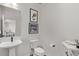 Stylish half bathroom with modern fixtures, decorative artwork, and a pedestal sink at 14998 Cast Pebble Cir, Parker, CO 80134