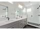 Elegant primary bathroom featuring double vanity, large mirror, and glass-enclosed shower at 14998 Cast Pebble Cir, Parker, CO 80134