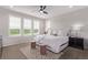 Bright bedroom featuring a ceiling fan, three windows with white shutters, and white bedding at 14998 Cast Pebble Cir, Parker, CO 80134