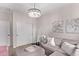 Cozy bedroom with a crystal chandelier, soft grey sectional, ottoman, and modern floral art at 14998 Cast Pebble Cir, Parker, CO 80134
