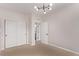 Bright bedroom featuring closet, modern light fixture, doorway to bathroom, and neutral carpet at 14998 Cast Pebble Cir, Parker, CO 80134
