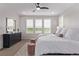 Bedroom featuring white bedding, three windows with shutters, and a black dresser at 14998 Cast Pebble Cir, Parker, CO 80134