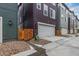 Street view of townhome garage with modern facade, wood accents, and convenient driveway at 14998 Cast Pebble Cir, Parker, CO 80134