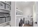 Organized laundry room features modern washer and dryer with ample shelving for storage at 14998 Cast Pebble Cir, Parker, CO 80134