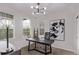 Bright office space features a modern desk, statement lighting, and large windows for natural light at 14998 Cast Pebble Cir, Parker, CO 80134