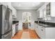 Modern kitchen featuring stainless steel appliances, white cabinetry, and hardwood floors at 1767 S Sherman St, Denver, CO 80210