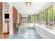 Inviting sunroom featuring brick walls, large windows, and rocking chairs, perfect for relaxing at 1767 S Sherman St, Denver, CO 80210