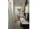 Hall bathroom featuring a vanity sink and a shower with a white curtain near a hall with storage at 1265 Yates St, Denver, CO 80204