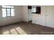Bright living room featuring a large window and neutral-toned carpet flooring leading into kitchen area at 1265 Yates St, Denver, CO 80204