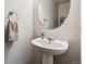 Cozy bathroom featuring a pedestal sink and an oval mirror at 6774 St Vrain Ranch Blvd, Firestone, CO 80504