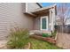A welcoming, covered entrance with stylish siding, a small garden, and a well-manicured lawn at 6774 St Vrain Ranch Blvd, Firestone, CO 80504