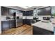 Modern kitchen boasts black cabinetry, stainless steel appliances, granite counters and wood flooring at 6774 St Vrain Ranch Blvd, Firestone, CO 80504