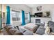 Bright living room features a cozy fireplace, a large gray couch and bright accents at 6774 St Vrain Ranch Blvd, Firestone, CO 80504