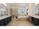 Bright bathroom featuring a soaking tub, tiled shower, and dual sinks at 6175 Puma Sands, Lone Tree, CO 80124
