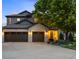 Charming home featuring a three-car garage, gray paint, brick accents, and a well manicured lawn at 6175 Puma Sands, Lone Tree, CO 80124