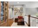 Upstairs hallway featuring a cozy seating area, hardwood floors, and decorative picture frames at 6175 Puma Sands, Lone Tree, CO 80124