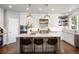 Bright kitchen features a large island with counter seating and stylish pendant lighting at 6175 Puma Sands, Lone Tree, CO 80124