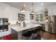 Modern kitchen with white cabinets, stainless steel appliances, and a large island with seating at 6175 Puma Sands, Lone Tree, CO 80124