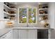 Bright kitchen with open shelving, stainless steel appliances, and a view of the trees at 6175 Puma Sands, Lone Tree, CO 80124