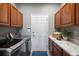 Well-lit laundry room featuring wood cabinets, tile accents, and a modern washer and dryer at 6175 Puma Sands, Lone Tree, CO 80124