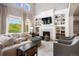 Cozy living room with a fireplace, built-in shelves, and comfortable seating with high ceilings at 6175 Puma Sands, Lone Tree, CO 80124
