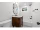 Clean bathroom with a white bathtub, wooden vanity, and marble countertop at 448 Brook Rd, Evergreen, CO 80439