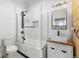 This bathroom features a tub with glass door, modern sink, decorative mirror and sleek, black fixtures at 1103 Lipan St, Denver, CO 80204