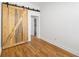 Bedroom with hardwood floors, a modern sliding barn door, and natural light at 1103 Lipan St, Denver, CO 80204