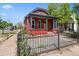 Attractive red-brick home with a covered porch and a black wrought iron fence at 1103 Lipan St, Denver, CO 80204