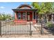 Charming red brick home with a covered front porch, stately columns, and a wrought-iron fence at 1103 Lipan St, Denver, CO 80204