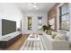 Bright living room featuring exposed brick, wood floors, large windows, and a modern white sofa at 1103 Lipan St, Denver, CO 80204