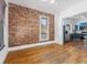 Inviting living room featuring a brick wall, hardwood floors, and an open layout at 1103 Lipan St, Denver, CO 80204