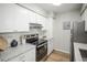 Bright kitchen featuring modern appliances, white cabinets, and sleek countertops at 3855 S Monaco St # 208, Denver, CO 80237