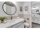 Well-lit bathroom with neutral tones, tiled walls, and a classic round mirror at 4248 Corriente Pl, Boulder, CO 80301