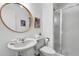 Bathroom features a stand up shower, pedestal sink, bright white walls and a large round mirror at 4248 Corriente Pl, Boulder, CO 80301