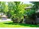 A view of the front of the house, with manicured lawn and lush trees at 4248 Corriente Pl, Boulder, CO 80301