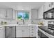 Bright kitchen features stainless steel appliances, white cabinets, and a view of the outdoor greenery at 4248 Corriente Pl, Boulder, CO 80301