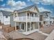 Two-story home with white balcony, gray siding, and landscaping with gravel at 13615 E 103Rd Ave, Commerce City, CO 80022