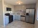 Modern kitchen features stainless steel appliances, light gray cabinetry, quartz countertops and ceramic tile flooring at 2246 N Coronado Pkwy # A, Denver, CO 80229