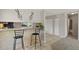Open kitchen view with breakfast bar and seating, featuring neutral tile floors and easy access to additional rooms at 2246 N Coronado Pkwy # A, Denver, CO 80229